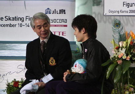 Takahiko Kozuka waiting for his marks with coach Nobuo Sato in the "Kiss and cry" area