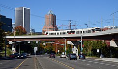 The Portland-Milwaukie extension at the south end of downtown Portland, on the viaduct carrying it over Harbor Drive and River Parkway Type 2 MAX train on TriMet bus and light-rail viaduct over Harbor Drive and River Pkwy (2019).jpg