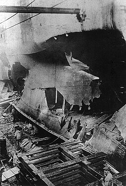 Torpedo damage to USS West Bridge seen in a French drydock c. 1918. One of the ship's boilers is visible in the left rear. USS West Bridge torpedo damage, boiler.jpg