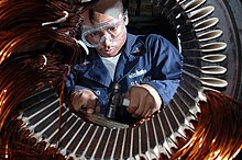 US Navy 091109-N-8960W-047 Electrician's Mate 3rd Class Tyreek Hayward lays coil to rewind a motor in the machine shop aboard the aircraft carrier USS Nimitz (CVN 68).jpg