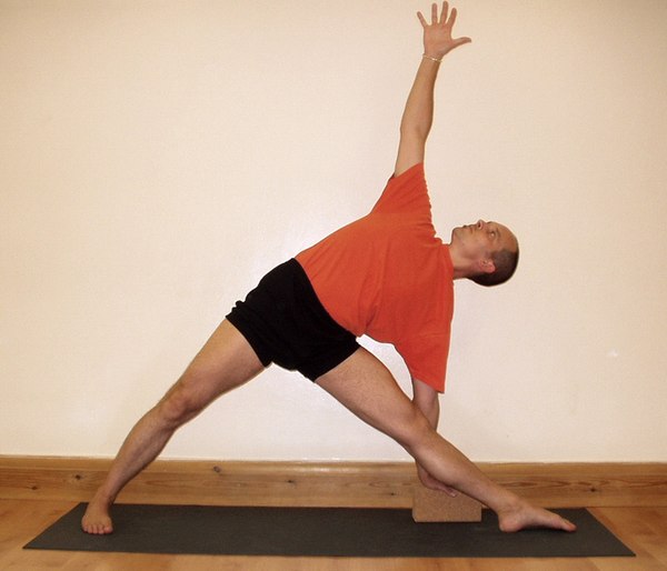 Utthita Trikonasana, with a Yoga brick to assist correct alignment