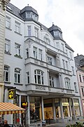 Residential and commercial building in closed development with an elaborately structured facade with loggias and plaster and stucco decoration of urban significance