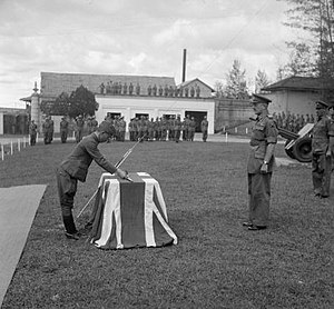 Captain Tomeichi Okazaki surrenders his sword to Major General Cameron Nicholson