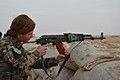 A YPJ soldier prepares to fire her automatic weapon.jpg