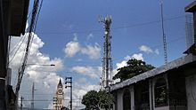 Estación de base de las oficinas de Movistar con reflectores parabólicos y antenas de array en la cúspide.