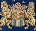 erb orámovaný na obou stranách dvěma žlutými lvy a převyšovaný korunou