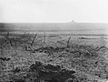 Champs de barbelés avec la tour Jeanne d'Arc à l'horizon.