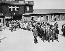 Groupe d'enfants rescapés de Buchenwald, encadrés par des soldats américains, soignés au Château de Vaucelles qui avait été transformé en hôpital. Texte historique très détaillé sur Commons