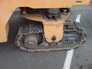 Small tracks on a roadworks machine. Note the rubber pads to reduce wear on the carriageway.