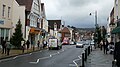 English: Dorking High Street, Dorking, Surrey, in July 2009. The photograph is taken looking roughly north east, with the A25 road heading towards Reigate. The photo was taken at roughly the highest point of the High Street, between the junctions of South Street and Lyons Court. File:Dorking High Street in July 2009 2.JPG was taken a few months earlier, showing the scene without Christmas decorations!