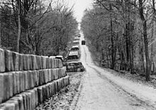 Stacks of jerry cans line a road.