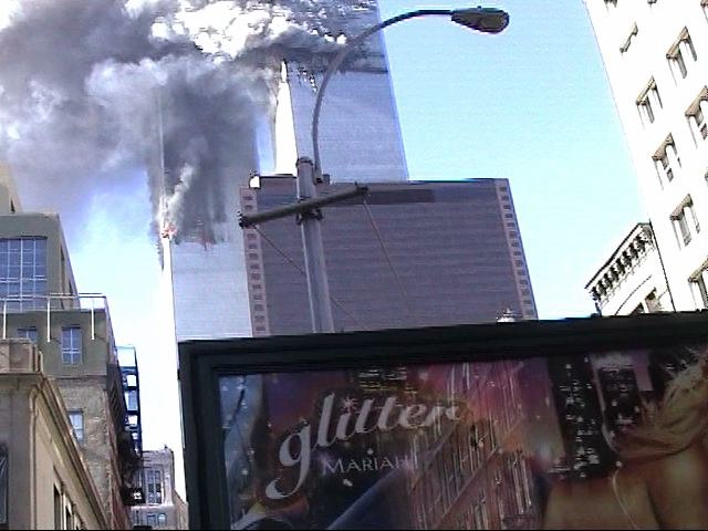 The Twin Towers burn behind an advertisement for the film.