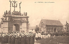 Photograph held by the Musée national des arts et traditions Populaires in Pleyben showing a procession passing by the Pleyben calvary on an unspecified date between 1903 and 1920.