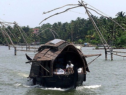 A house boat seen in Ashtamudi lake with Chinese nets in the background