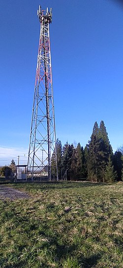 U vrcholu, ocelový příhradový stožár s vysílačem