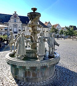 Historical fountain on the town hall square with the town hall in the background