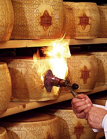 After nine month of aging, each wheel gets checked and, if considered of adequate quality, gets fire-branded with the Grana Padano logo. Marchiatura 2.jpg