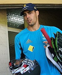 Mitchell Johnson stands side on with his body pointing left. His hands are together and his look looks concentrated.