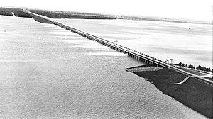 The Morganza Spillway, between the Mississippi River and the Atchafalaya Basin, shown while open in 1973. Water flows from the Mississippi (upper right) into the Morganza Floodway (lower left). Morganza Spillway Aerial.jpg