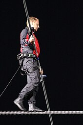 A man in black and red clothing on a tightrope