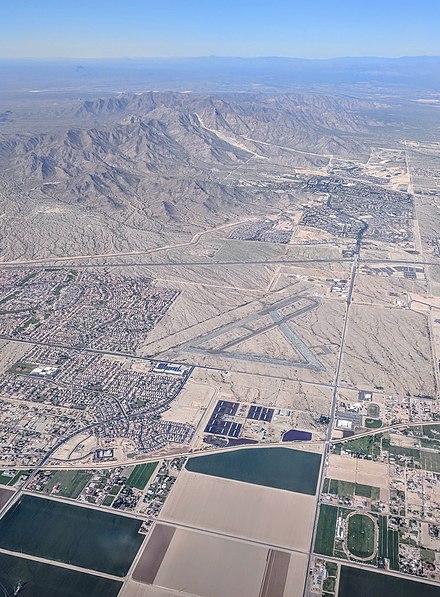 Aerial view from the south, of the northeast corner of Buckeye, Arizona, with the abandoned Goodyear Field, or Luke Air Force Auxiliary Airfield#6, a training field used during WWII, between the Roosevelt Irrigation District main canal and Interstate 10. Goodyear, Arizona, is the adjacent city to the east (right).