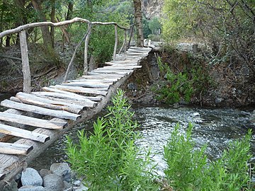 Ponte pedonale in legno che attraversa la fiumara