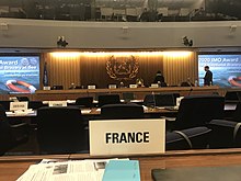 La photographie montre la pancarte France sur le banc où siège la délégation française à l'Organisation Maritime Internationale.