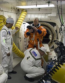 Closeout crew members help astronaut Andrew Feustel in the Launch Complex 39 white room prior to launch of STS-125 STS white room.jpg