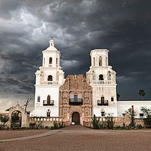 Large white Mexican style church against an overcast sky