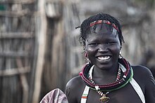 A young south sudanese girl smiling in tradition attire South Sudan 003.jpg