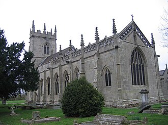 A grey stone church seen from the southeast, showing a chancel with a Perpendicular east window, an openwork parapet and pinnacles and, beyond that, the nave and a tower, also with pinnacles