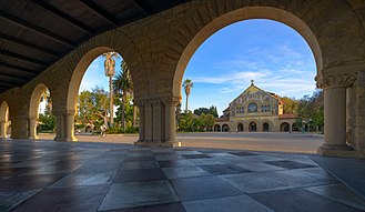 Stanford University is adjacent to Palo Alto Stanford University Arches with Memorial Church in the background.jpg