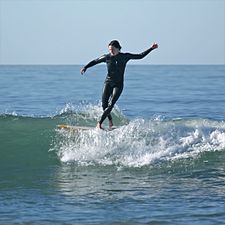 Skicklig kvinnlig surfare på longboard i Pacific Beach, Kalifornien