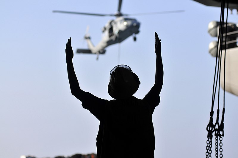 File:US Navy 120113-N-ZI635-342 Boatswain's Mate 3rd Class Charlesa Anderson signals to the Military Sealift Command fast combat support ship USNS Raini.jpg