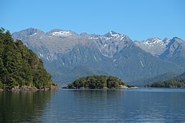 Vue au-delà de l'île de Mahara (lac Manapouri) en direction de Cathedral Peaks.jpg