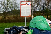 A multi-language sign in Germany telling people to dispose of waste food in closed waste bins to prevent boars eating it Warnschild an einem Autobahnparkplatz in Baden-Wurttemberg bei Bickelberg 02.jpg