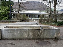 Sekundarschule Liestal. Widmann-Brunnen, Relief „Der Heilige und die Tiere“. Eingeweiht am 6. Nov. 1961. Das Relief ist heute nicht mehr am Brunnen zu sehen.