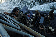A NAVSOG unit climbs a caving ladder aboard the BRP Dagupan City during a maritime interdiction exercise.
