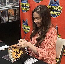 Writer Marjorie Liu autographing a copy of the Daken/X-23: Collision trade paperback at a signing at Midtown Comics in Manhattan