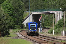 Een TER komt het station binnen, gezien rechts van een mechanische semafoor.