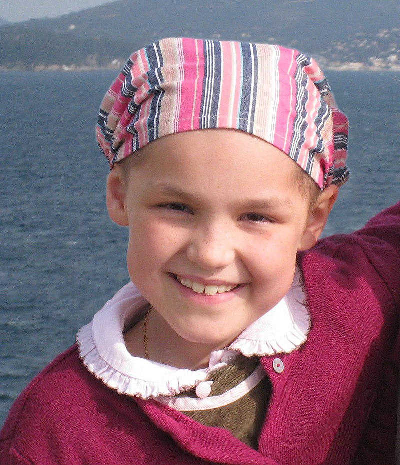 Photo en couleur d'une fille souriante, devant la mer