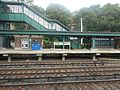 Standard Helvetica sign on the Poughkeepsie-bound platform in front of a staircase leading to the pedestrian bridge.