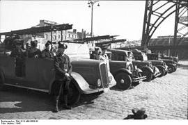Inspection de l'amiral allemand Lindau à Bordeaux, quai des Chartrons, 1942.Le Bootsmann Stemper (LS off) pose devant les camions du port