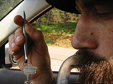 A person inhaling a cannabis concentrate aerosol using a dab rig.