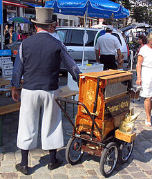 A barrel organ player in Warnemunde, Mecklenburg-Vorpommern, Germany Drehorgel Leierkasten Charly.jpg