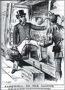 "Farewell to the Caucus": 1886 cartoon of Francis Schnadhorst, Secretary of the UK National Liberal Federation, leaving Birmingham for London following the split in the party over Irish Home Rule. His luggage includes a scroll marked "Caucus", several string puppets, and a box of "wire pulling machinery", all in allusion to his reputation as a backstage political manager. Francis Schnadhorst cartoon 1886.jpg