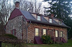 Kırmızımsı taştan yapılmış küçük bir ev. Üç pencereli kavisli bir çatıya sahiptir. Çatının üst kısmına yakın evin dış cephesi bordo renkli ahşaptır.