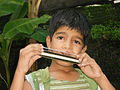 1. Jongen bespeelt een mondharmonica.