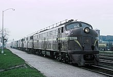 PRR E8 diesel locomotive with trainphone antenna PRR E8A 5766 with WB the Manhatten Limited and the Golden Triangle at Englewood Union Station (Chicago, IL) on April 21, 1965 (37666520842).jpg