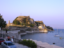 Palaio Frourio south elevation. The Venetian built moat is on the left and the Doric style St. George's Church built by the British can be seen in the background on the right. Palaio Frourio in Corfu.png